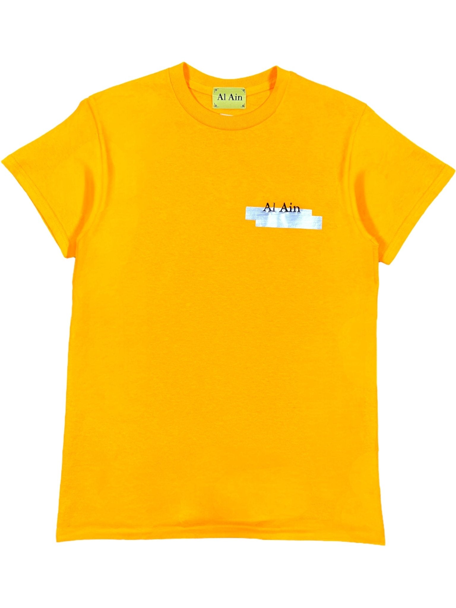 The Al Ain AMHX S120 Jabalia Ocre Yellow is a bright yellow short-sleeve graphic tee with a small embroidered "AL AIN" on the chest and inside the collar. Made in Italy.