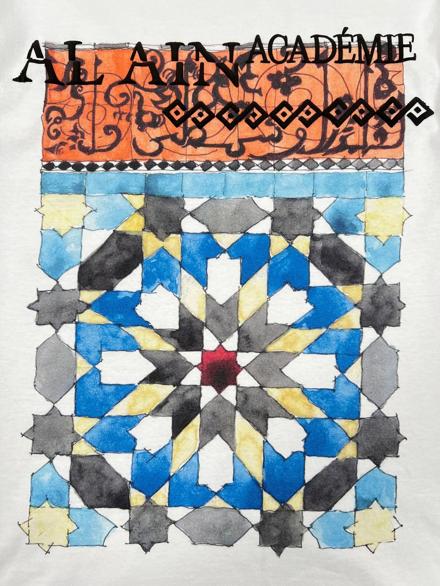 The Al Ain AMHX-S815 Haj T-shirt White by AL AIN features a geometric mosaic pattern with blue, yellow, gray, and black shapes under an orange border and subtle black text. Made in Italy from 100% cotton.