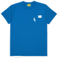 The AL AIN Al Ain AMHX-S818 Majorelle T-shirt Orient is a blue short-sleeve 100% cotton tee with a small white text graphic, left chest patch, and “Al Ain” labeled on the neck tag.