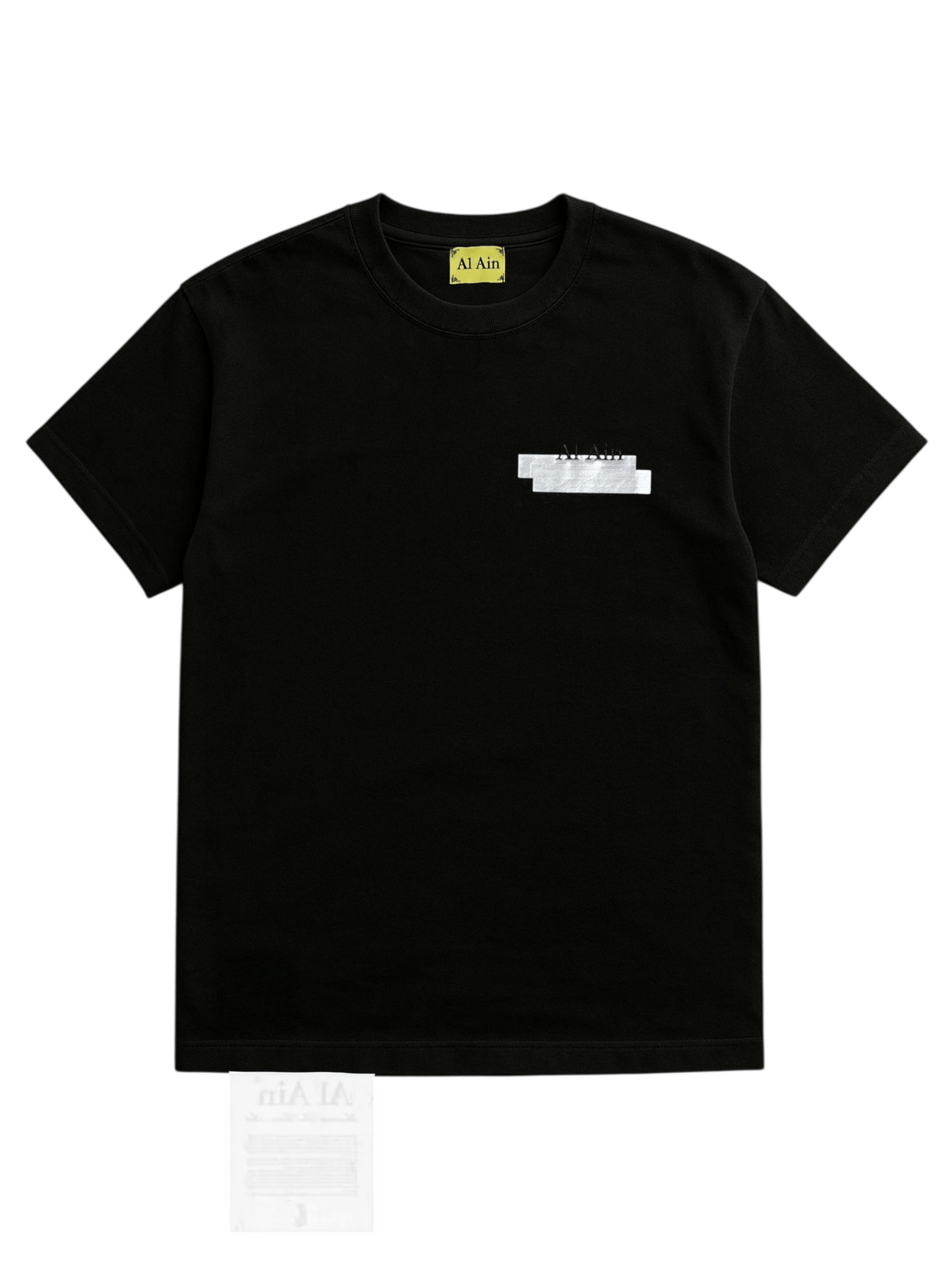 The AL AIN Al Ain AMHX-S870 Detruit T-shirt Black is a 100% cotton, Italian-made black short-sleeve tee with a yellow "Al Ain" neck label and a small white graphic on the upper left chest.
