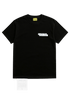 The AL AIN Al Ain AMHX-S870 Detruit T-shirt Black is a 100% cotton, Italian-made black short-sleeve tee with a yellow "Al Ain" neck label and a small white graphic on the upper left chest.