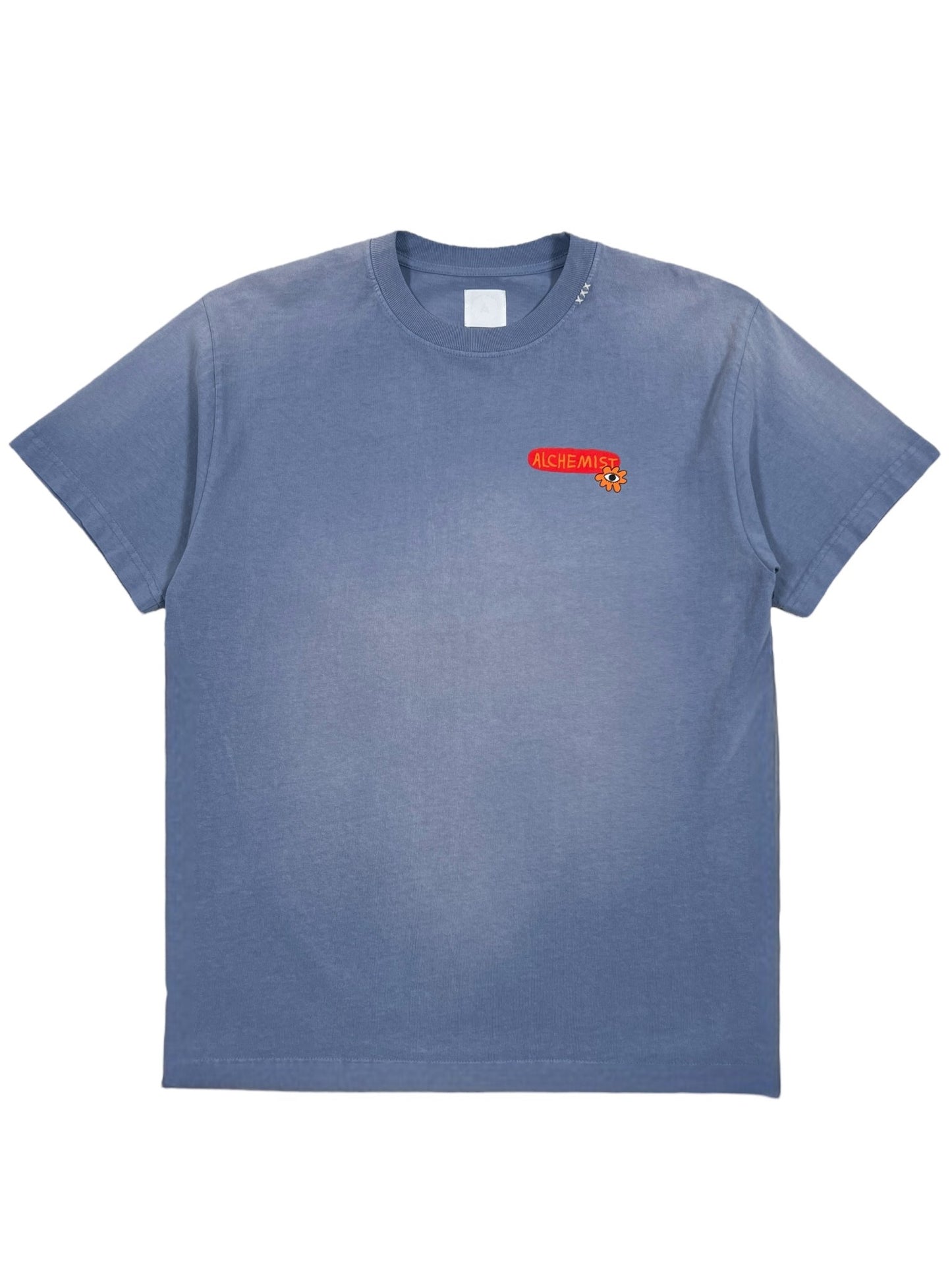 This image showcases the ALCHEMIST ALL-SEEING CACTUS TEE BREEZE BLUE, a stylish short-sleeve graphic T-shirt featuring a small red "ALCHEMIST" logo on the left chest area. The shirt sports a crew neckline and boasts a vintage washed finish for added flair.