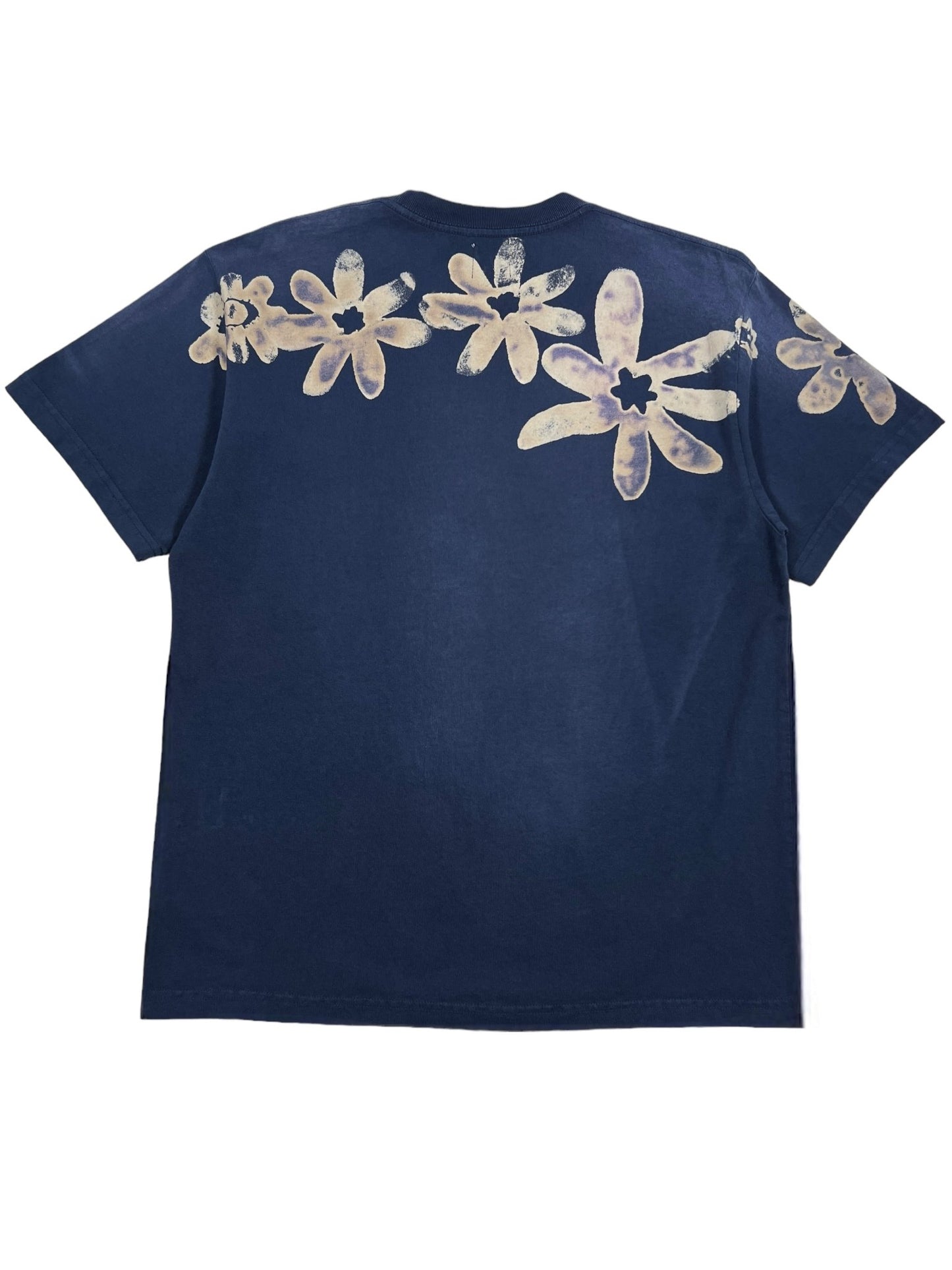 A nightfall blue graphic t-shirt from ALCHEMIST, named the BLOCK PRINT S/S TEE, featuring light-colored floral designs across the upper back and completed with a vintage washed finish for that classic ALCHEMIST touch.