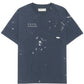 The Domrebel Atelier Pocket Tee in dark blue by DOM REBEL features a white paint splatter design, chest pocket, and "D.R.S.M. Atelier" text, offering an edgy fashion style.