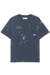 The Domrebel Atelier Pocket Tee in dark blue by DOM REBEL features a white paint splatter design, chest pocket, and "D.R.S.M. Atelier" text, offering an edgy fashion style.