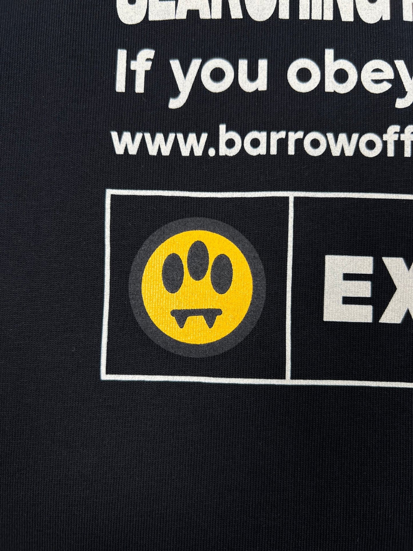 Close-up of the Barrow S5BWUATH066 Jersey T-shirt in black, made in Italy. It features white text and a web address, with a yellow circle icon displaying a paw print and fangs for extra style on its 100% cotton fabric. Brand: BARROW.