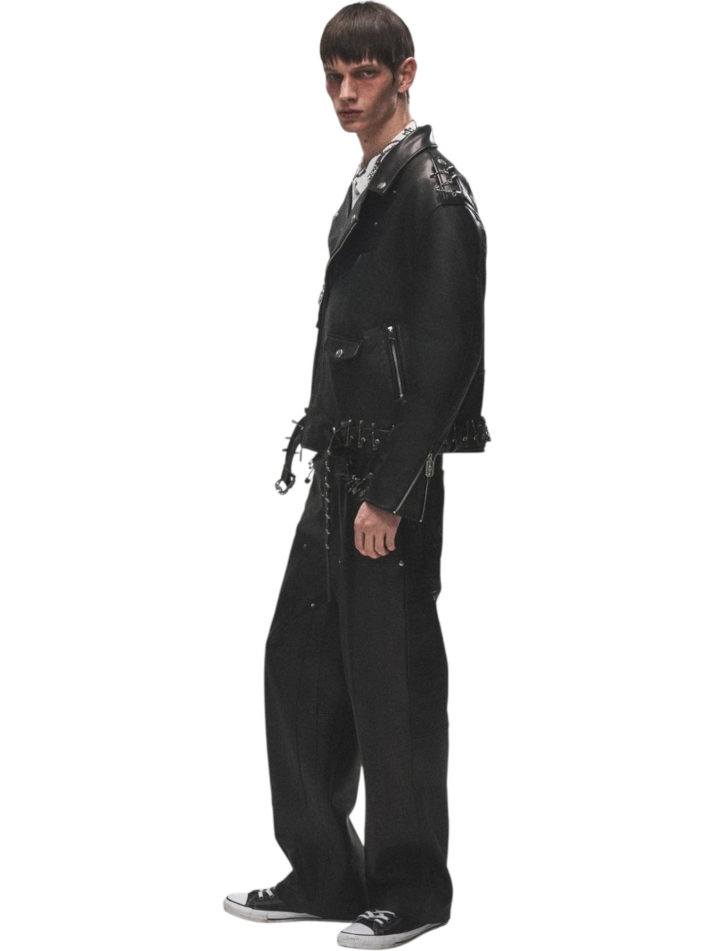 A person wears the BIRTH OF ROYAL CHILD Birth Of Royal Child BC25SSJK09 Pin Detail Leather Jacket in black, paired with wide-leg pants and black Converse sneakers, against a white background.