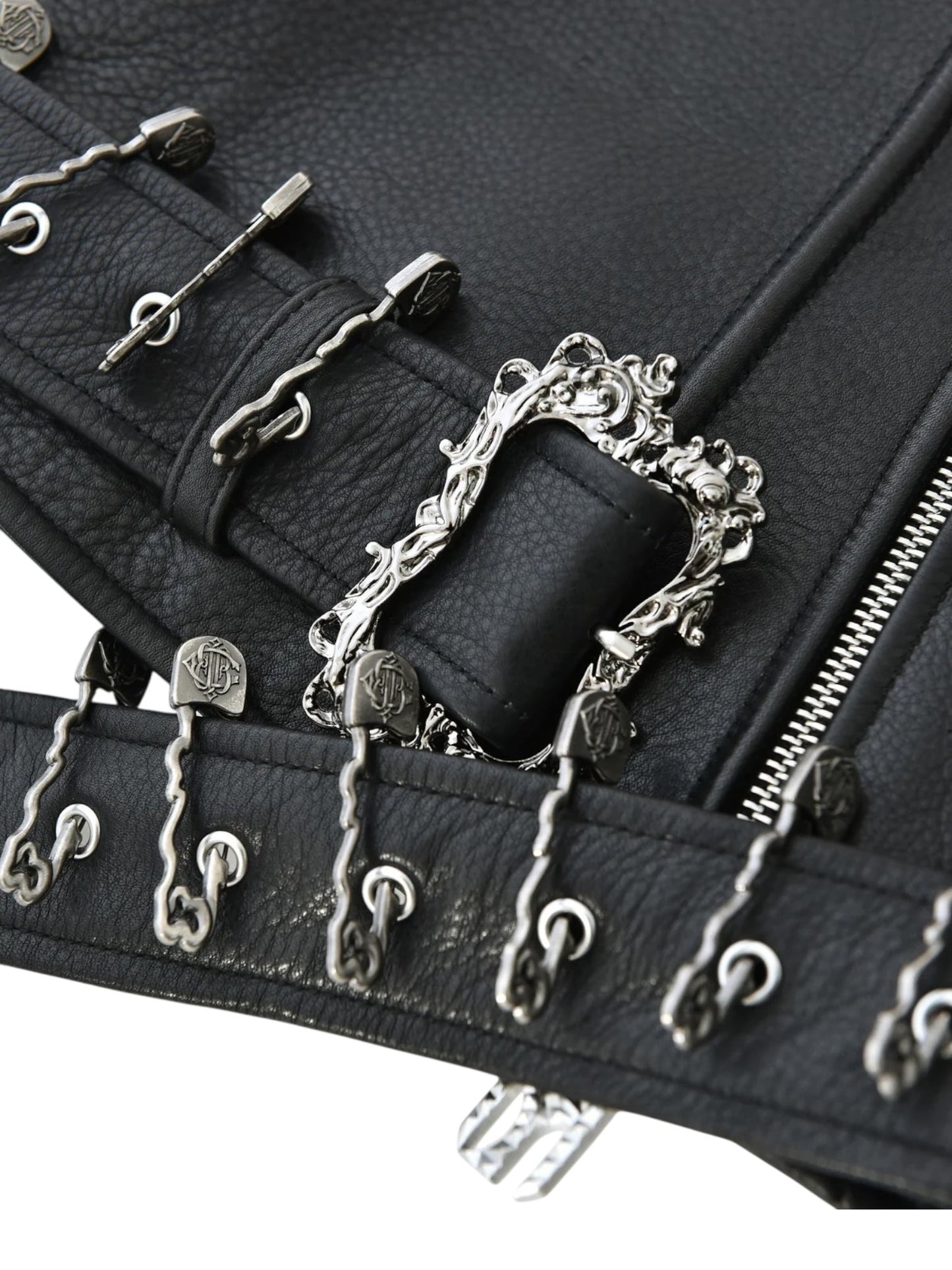 Close-up of the BIRTH OF ROYAL CHILD Birth Of Royal Child BC25SSJK09 Pin Detail Leather Jacket Black, featuring motorcycle-inspired design with ornate silver buckles, decorative metal hooks, and a visible zipper.
