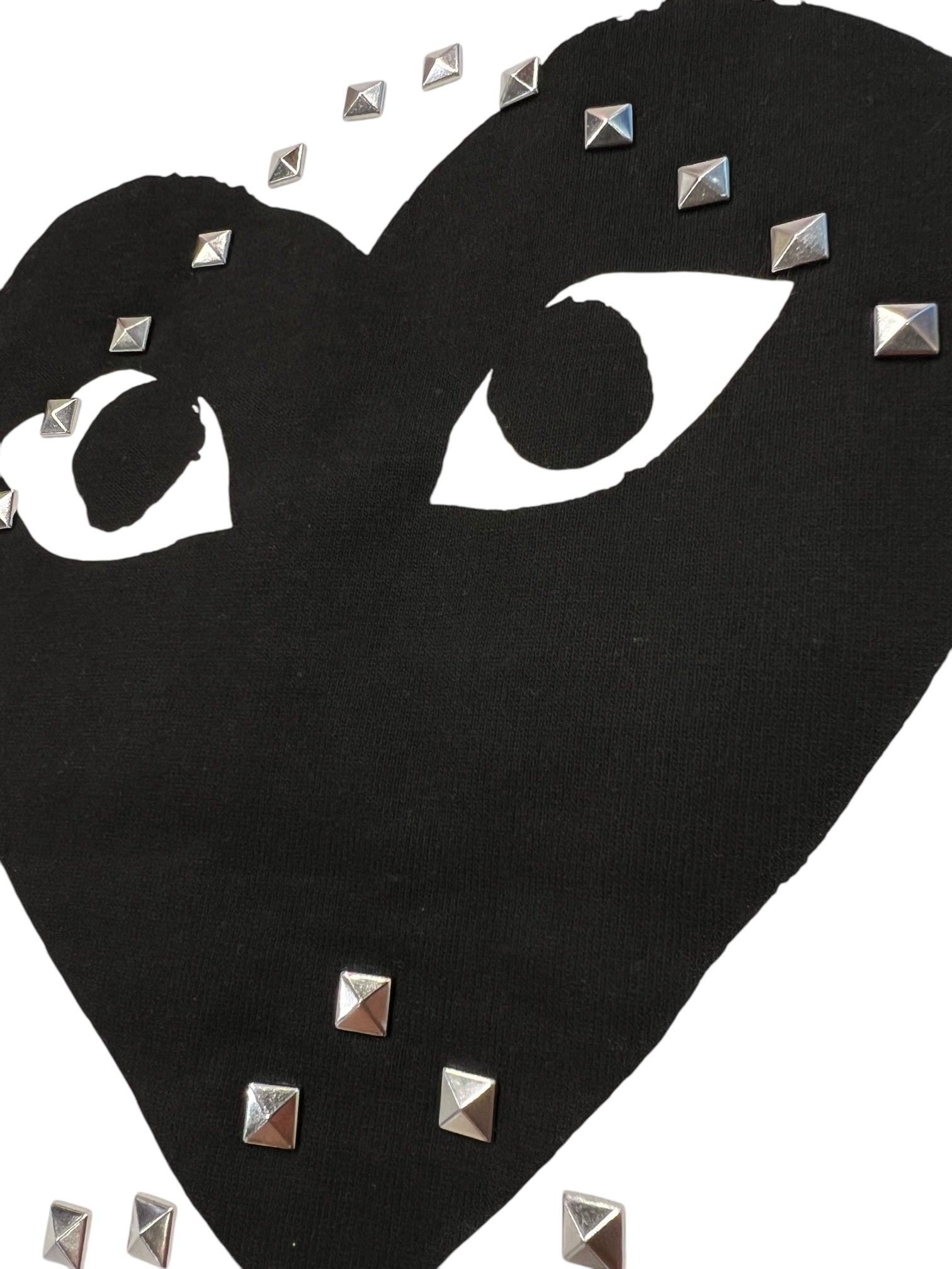 The Comme des Garcons P1T804 T-SHIRT LOGO STUD WHITE by COMME DES GARCONS X PLAY features a black heart-shaped logo with eye cutouts and silver square studs on white 100% cotton—ideal with your favorite CDG tee.