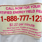 Close-up of a beige sign advertising a certified energy field reading for $2.22 per minute. Requires over 18 years of meditation and telepathy phone. Sponsored by Spiritual Communications, Bermuda Triangle. The reader wears a CRTFD AYURVEDIC T-SHIRT NATURAL made from 100% organic cotton for authenticity and comfort.