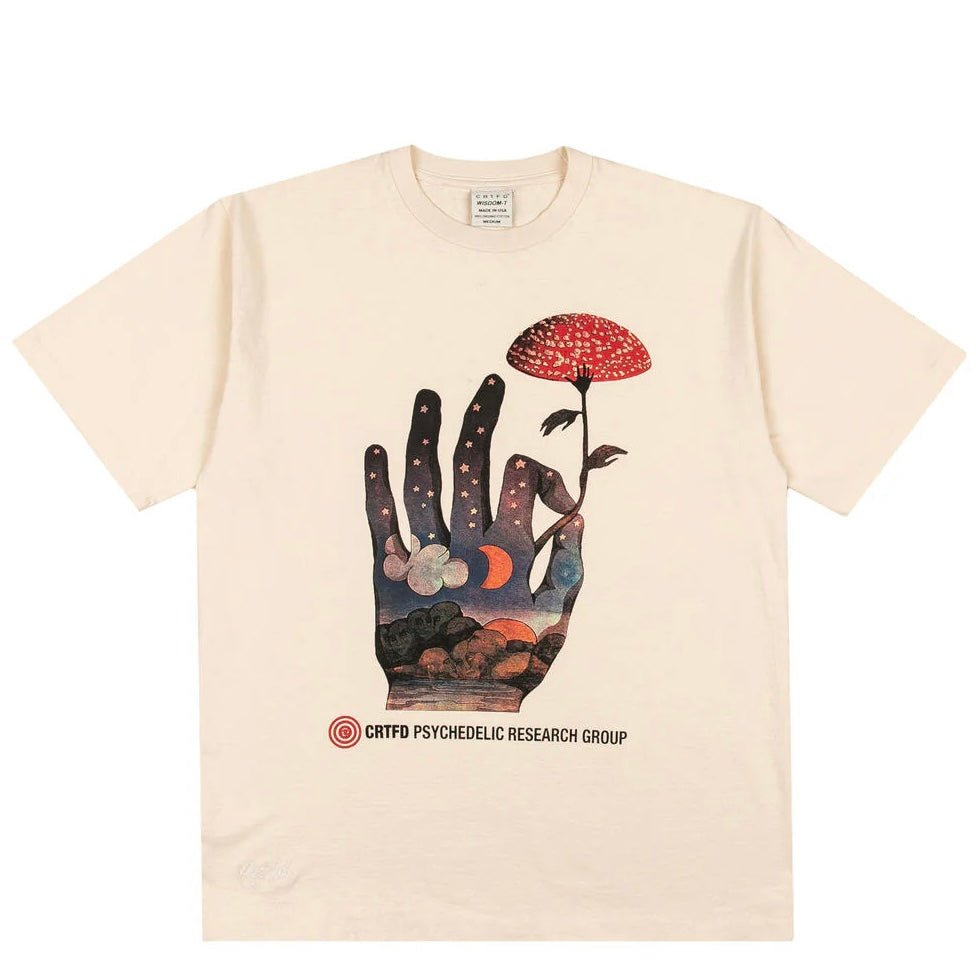 The CRTFD FLY AGARIC T-SHIRT NATURAL, crafted from organic cotton, showcases a hand holding a red mushroom with a psychedelic night sky design. The text "CRTFD PSYCHEDELIC RESEARCH GROUP" is displayed at the bottom.