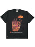 The CRTFD FLY AGARIC T-SHIRT VINTAGE BLK is a black T-shirt made from organic cotton, showcasing a colorful hand holding a mushroom and the text "CRTFD PSYCHEDELIC RESEARCH GROUP" underneath.