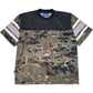 The DEVÁ STATES Ballistic s/s Mesh Jersey Top Camo features a black upper chest, white and gray striped sleeves, mesh jersey panels, and small logo patches on the chest and hem.