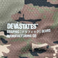 The Deva'States Ballistic s/s Mesh Jersey Top Camo by DEVÁ STATES is a polyester camo mesh jersey with white "DEVA STATES® GRAPHIC [グラフィック] GEARS MANUFACTURING CO." print.