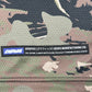 Close-up of camouflage-patterned polyester fabric with a "GRAPHIC GEARS MANUFACTURING CO." label. Perfect to pair with the DEVÁ STATES Deva'States Ballistic s/s Mesh Jersey Top Camo.