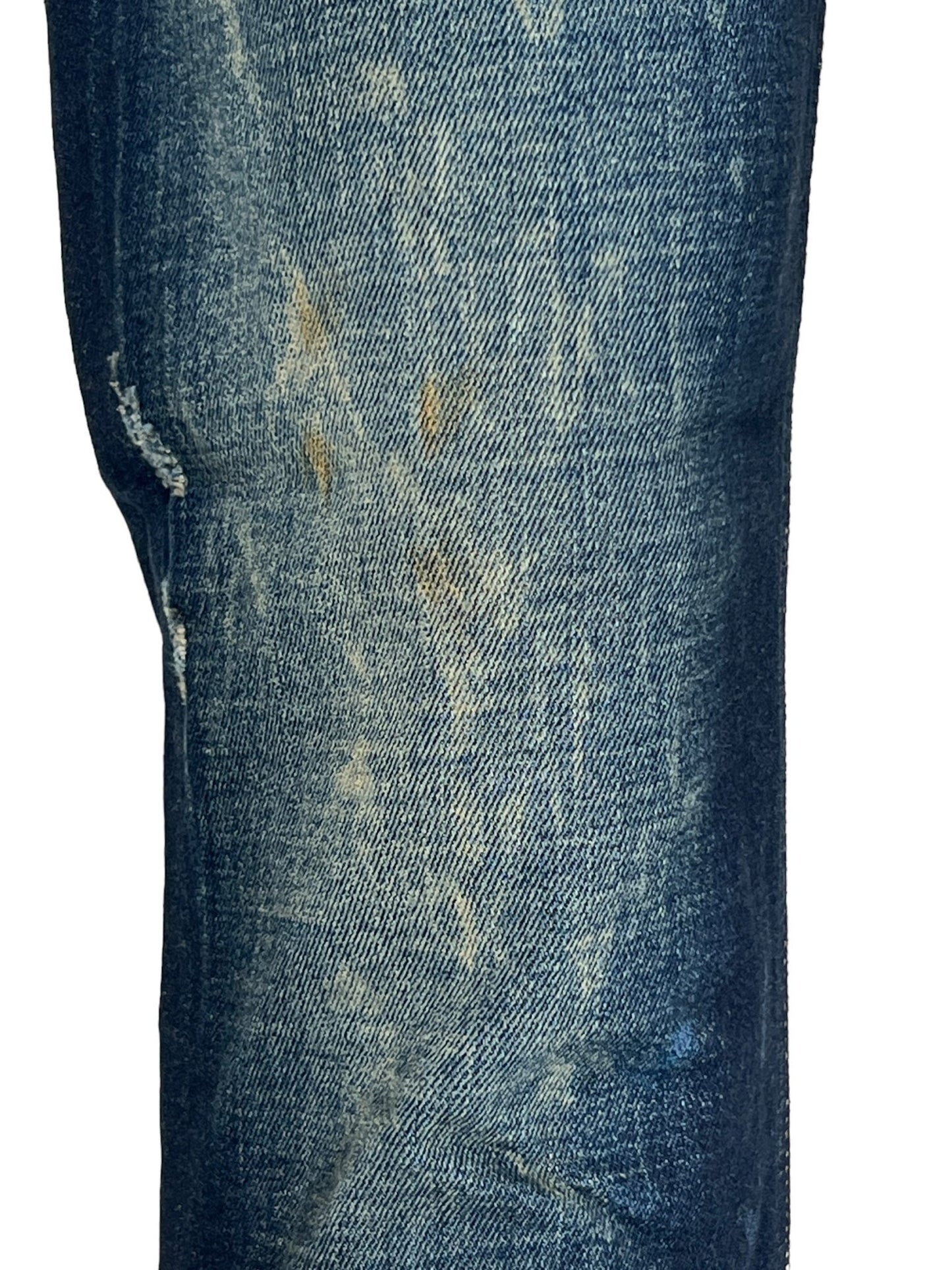 Close-up of a leg wearing the DIESEL 1979 SLEENKER 9J26 skinny jeans, with a zip fly, in faded blue denim that showcases visible wear and slight discoloration.