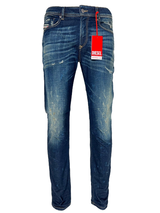 A pair of worn blue DIESEL 1979 SLEENKER 9J26 skinny jeans with a red DIESEL tag attached, featuring slight distressed details on the thighs and knees, and a zip fly.