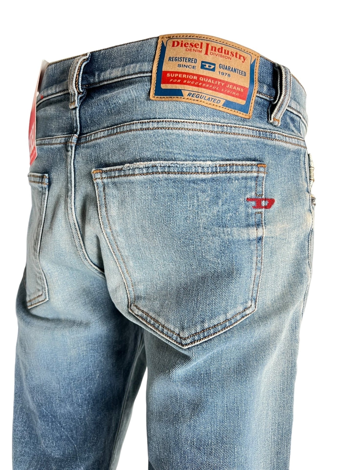 Rear view of DIESEL 2019 D-STRUKT 07V8 blue jeans featuring back pockets, a brown leather brand patch, and a red logo tab, crafted from organic cotton.