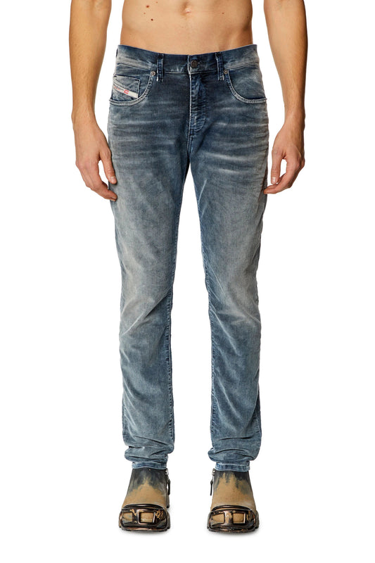 Man standing in DIESEL 2019 D-STRUKT 68JF jeans and black sandals against a white background.