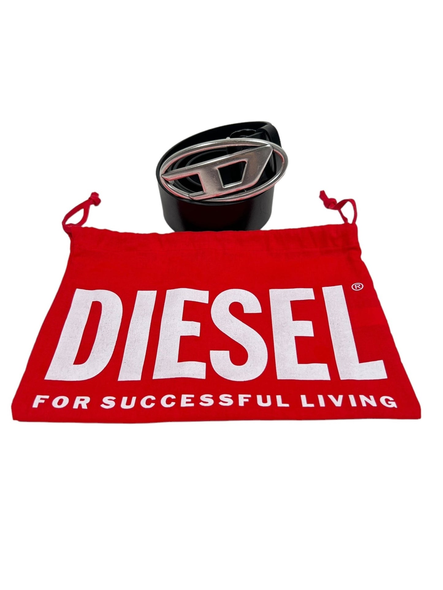 A DIESEL B-1DR LEATHER BELT W SILVER D BUCKLE with a large metallic 'D' logo buckle is displayed next to a red Diesel drawstring pouch that reads "DIESEL FOR SUCCESSFUL LIVING" in white text, evoking the style of the SS22 Fashion Show.