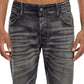 A person wearing the DIESEL D-BACKLER-RR 9J65 distressed dark-wash bootcut jeans with a tattoo visible on the torso. The image is cropped to show from the waist down to the upper thigh.