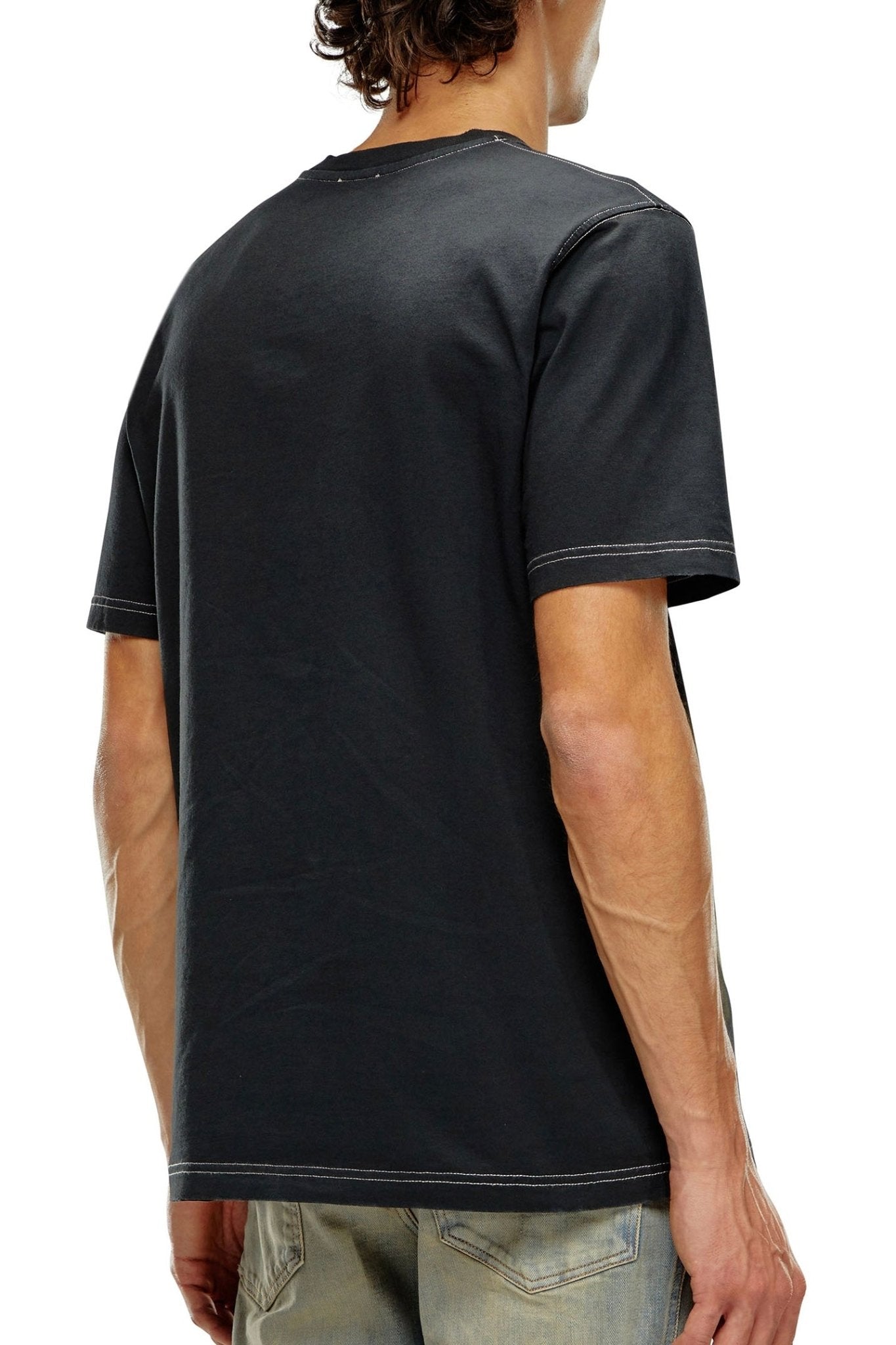 Man wearing a plain black cotton jersey DIESEL pT-JUST-N13 T-SHIRT BLACK Men's T-shirt, viewed from the back.