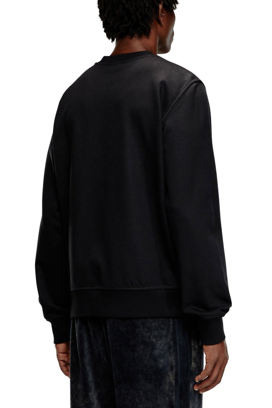 Person wearing a black DIESEL S-GINN-K43 SWEAT BLACK hoodie and dark pants, viewed from the back.