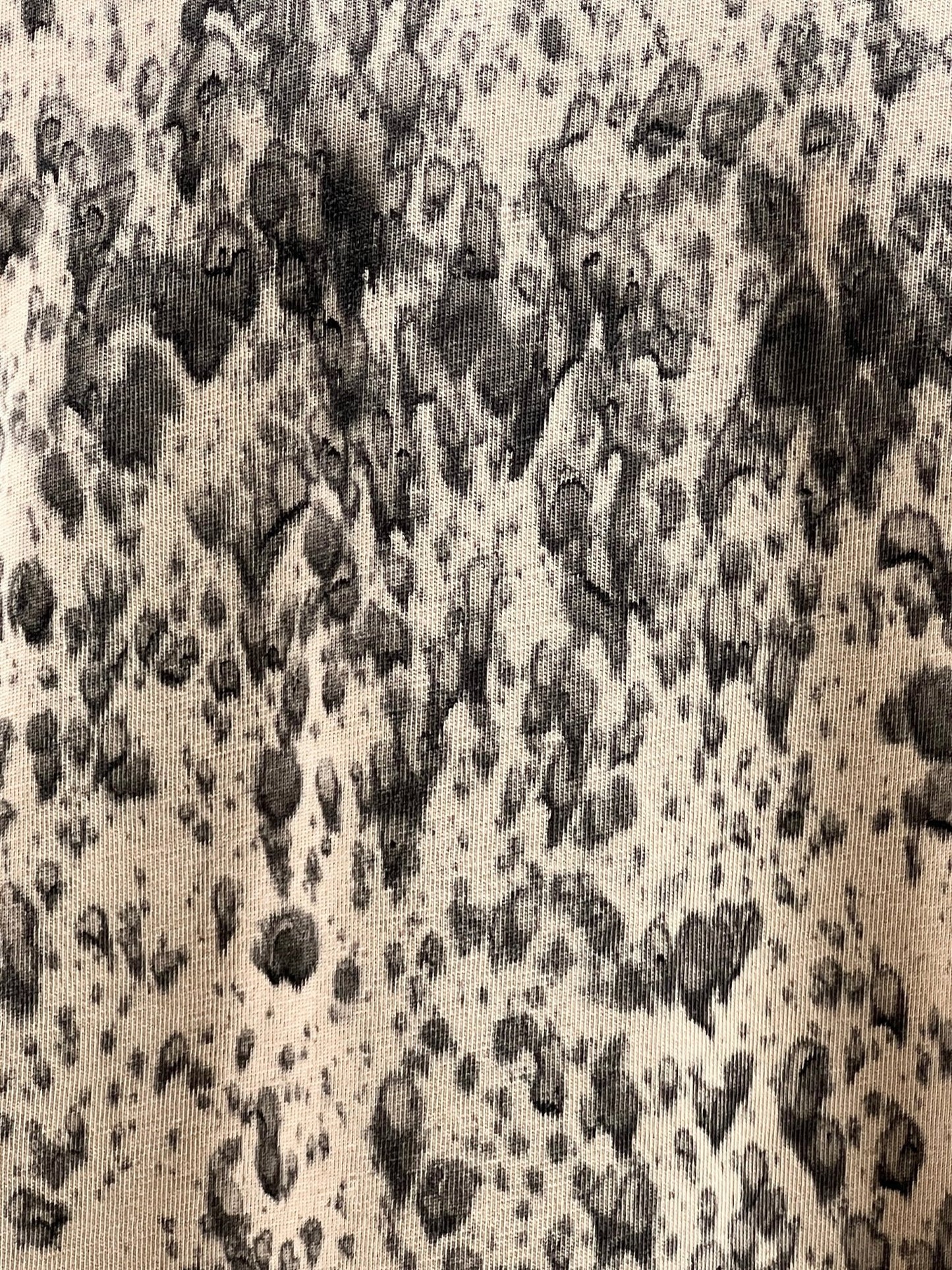 Close-up of a DIESEL T-BOXT-K6 T-SHIRT LIGHT BROWN fabric showcasing a black and grey abstract pattern resembling ink splatters on a beige 100% cotton background.