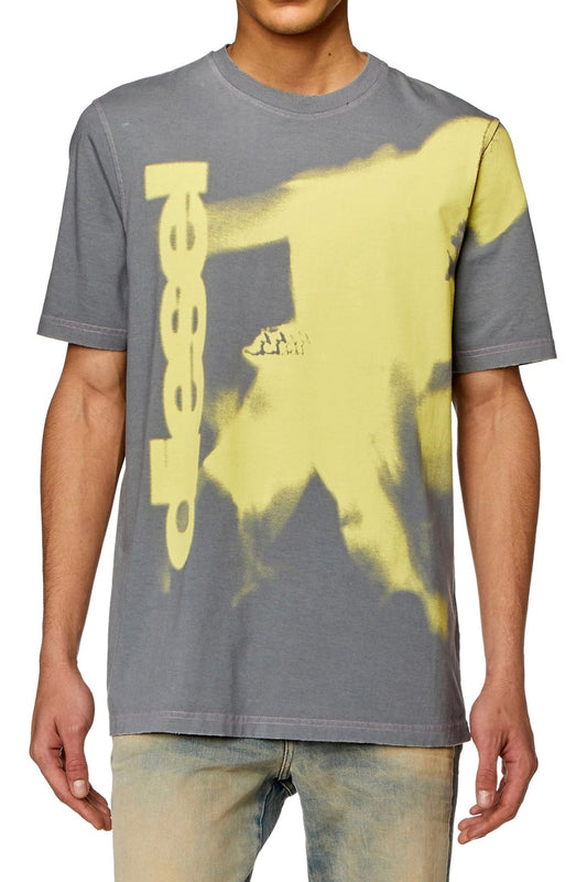 Man wearing a DIESEL T-JUST-N13 T-SHIRT GREY with a yellow abstract design and logo.