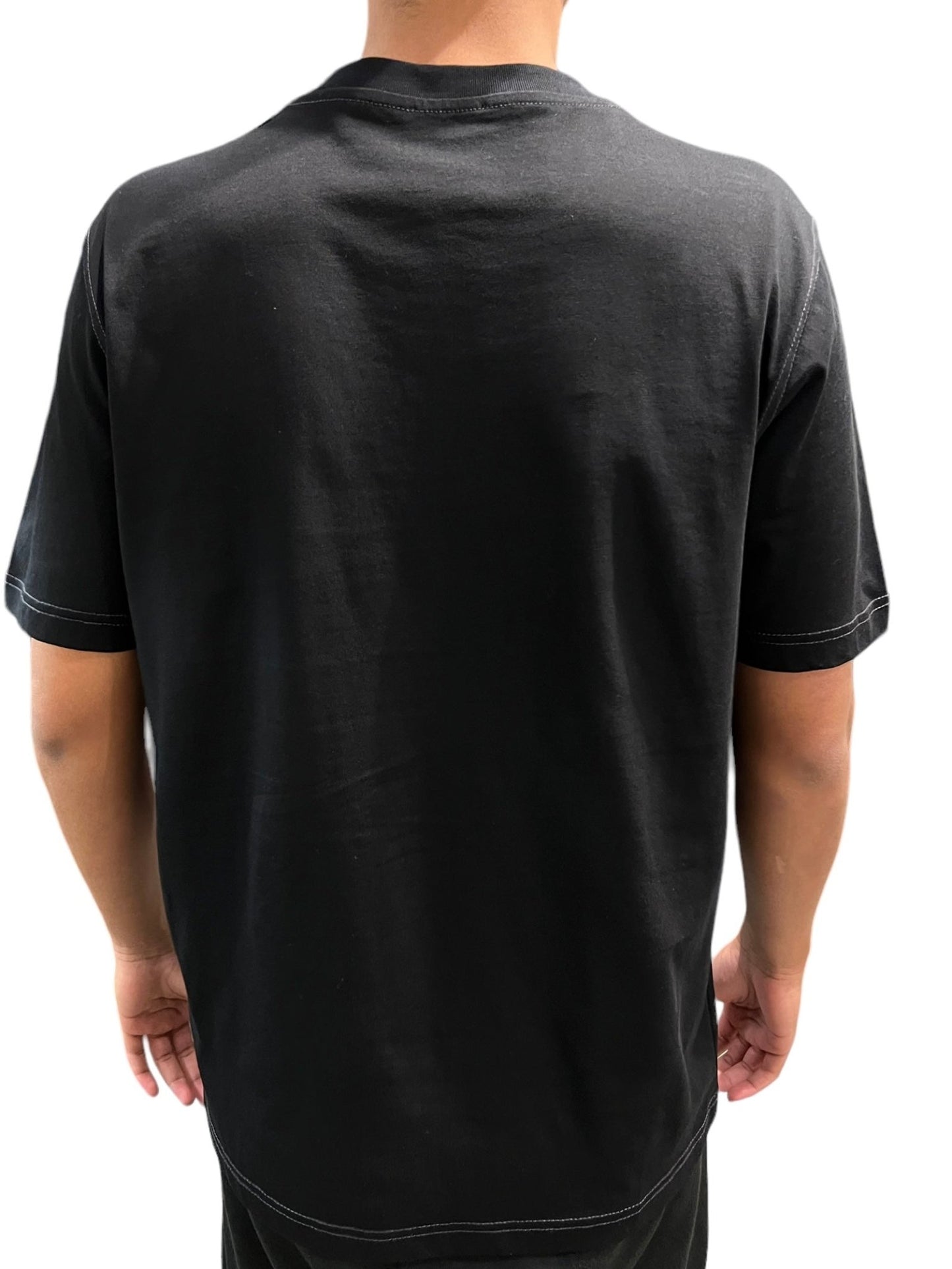 Rear view of a person wearing a DIESEL T-JUST-N14 T-SHIRT BLACK made from organic cotton jersey.