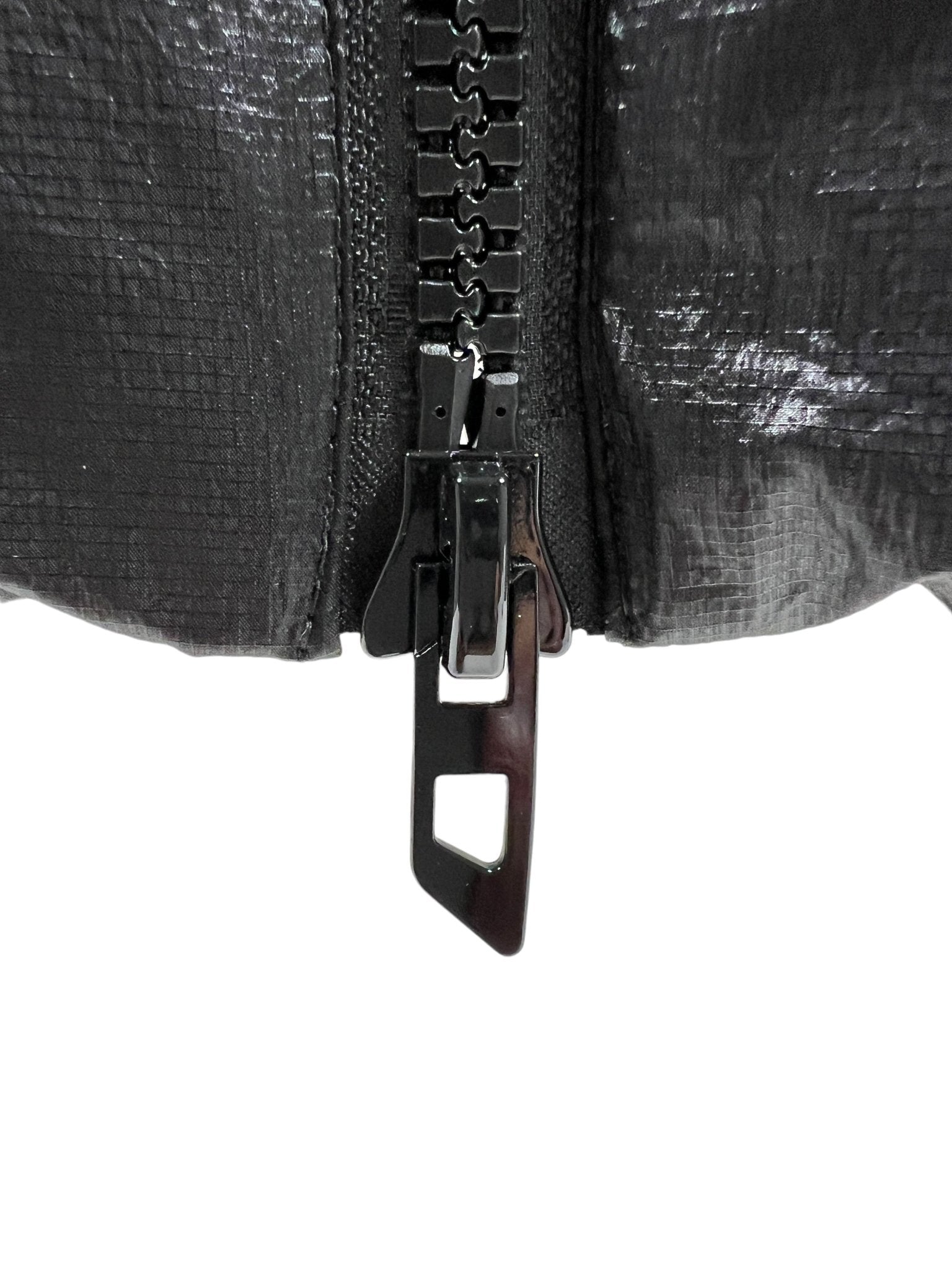 Close-up of the Diesel W-Ostend Jacket Black by DIESEL, showcasing a black zipper on its shiny, textured, recycled polyester fabric. The zipper is partially unzipped to reveal the teeth and pull tab.