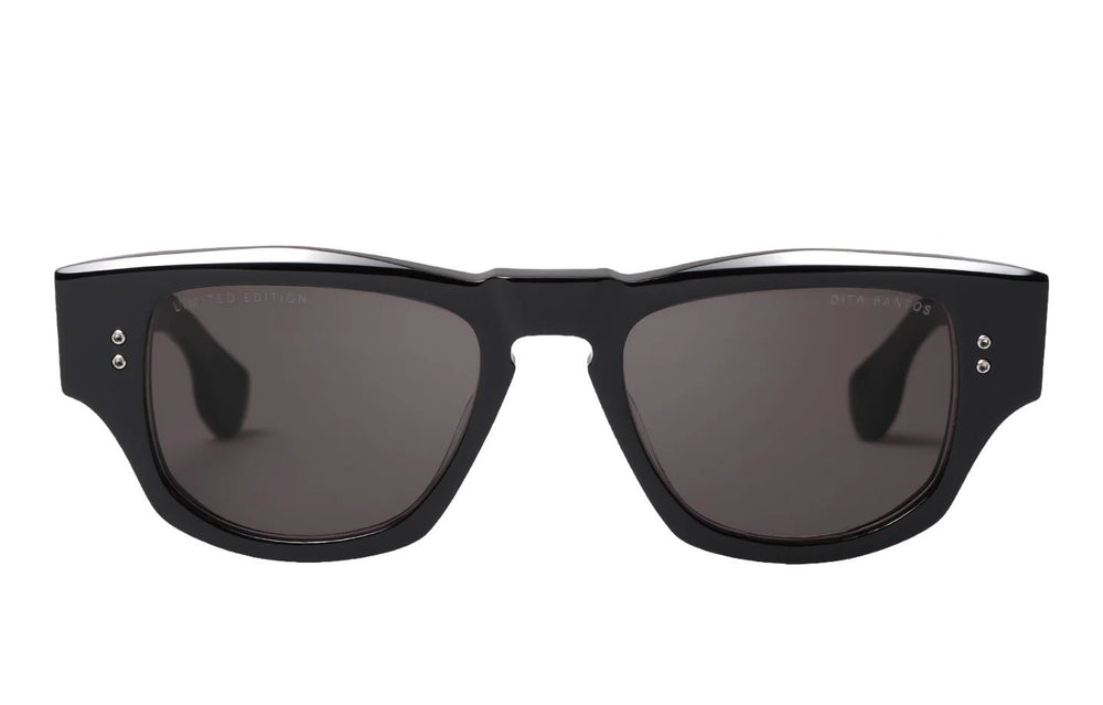 A pair of black rectangular DITA BANTOS DTS723-A-01 sunglasses with dark lenses and two small metal accent dots on each temple, featuring a sleek acetate frame.