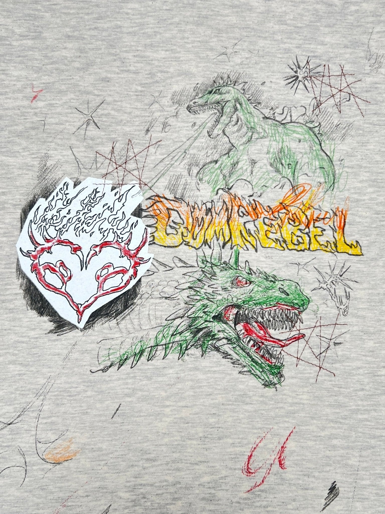The Domrebel Conflict T-shirt Greige by DOM REBEL features an abstract design with a dinosaur, flame-bordered mask, red and yellow text, and colorful scribbles, all highlighted by the original Domrebel doodle graphic on its gray fabric.