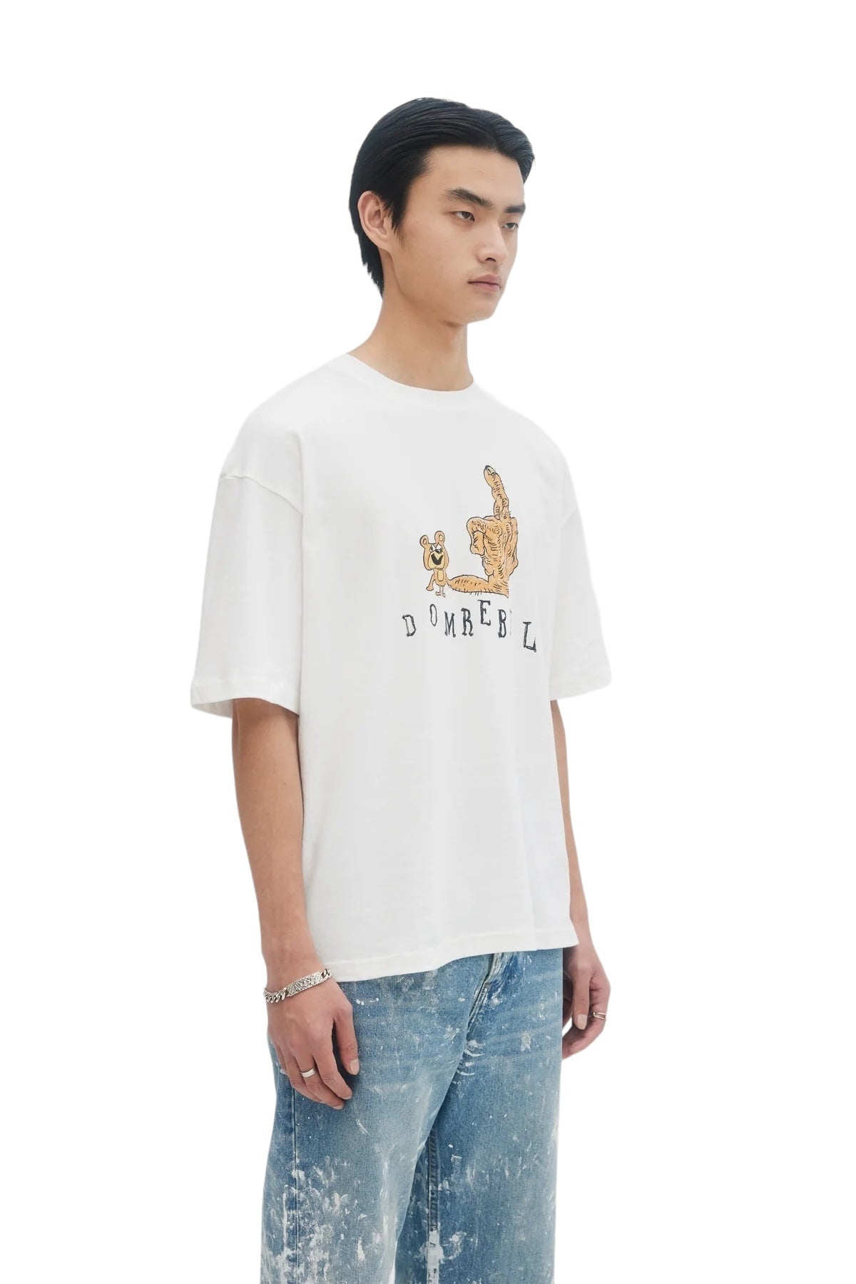 A person in a DOM REBEL Domrebel Friendly Ivory T-shirt, featuring a hand-drawn teddy bear, pairs it with blue jeans against a plain background.