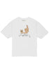 The Domrebel Friendly T-Shirt Ivory by DOM REBEL showcases a hand-drawn teddy bear with a sign, lounging beside a statue, and the bold "DO REBEL" text below. Part of the bon vivant collection, it adds quirky charm to any outfit.