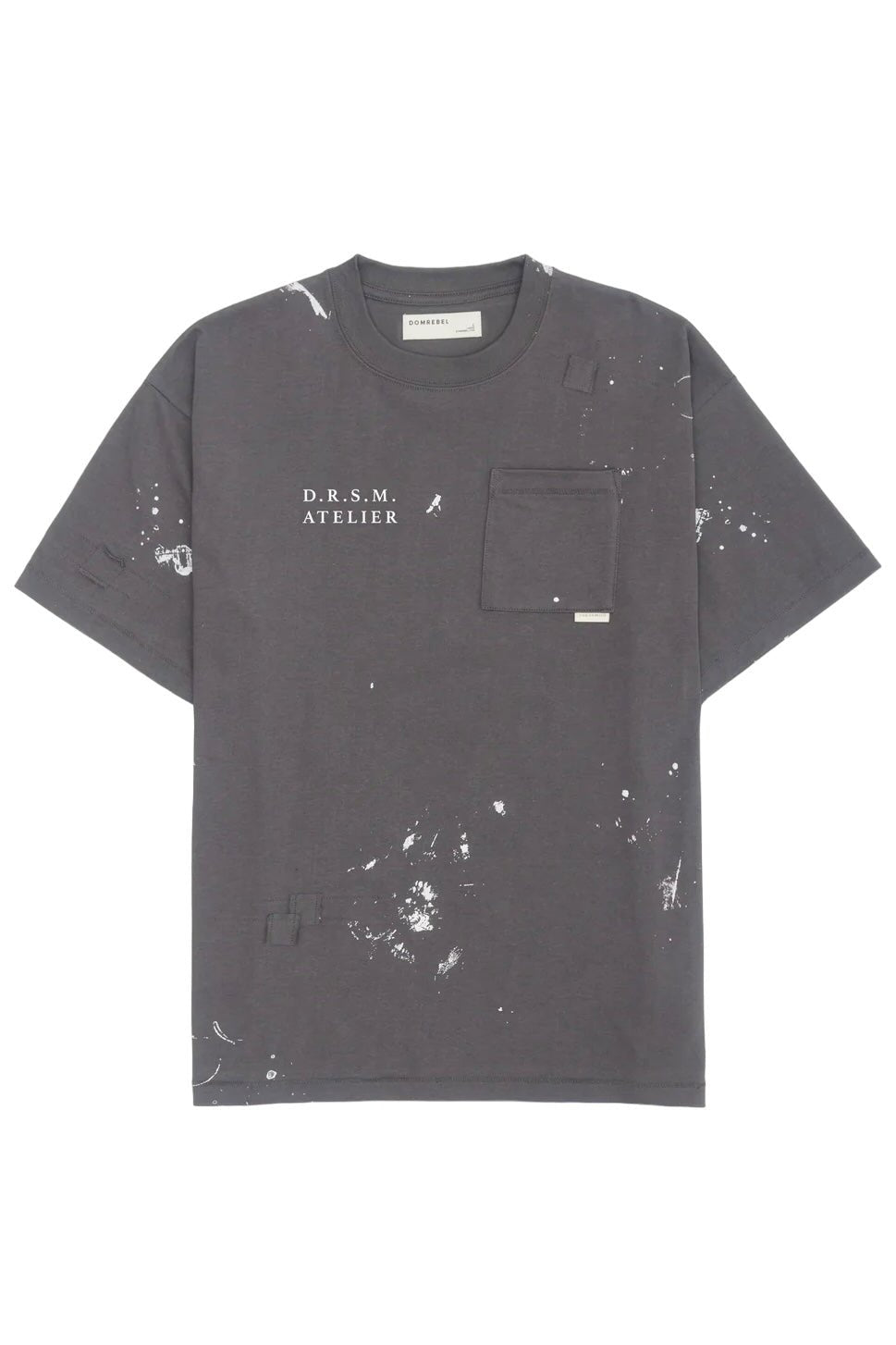 The Domrebel Atelier Pocket Tee Coal Paint by DOM REBEL features "D.R.S.M. ATELIER" text, a chest pocket, signature paint splatter design, and a small label.