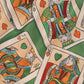 Scattered playing cards with face card designs on a patterned green background, featured in the Drole de Monsieur D-BS141-PL136 Le Short Plage Jeu de Cartes GN swim shorts' card game print with an elastic waist and drawstring.