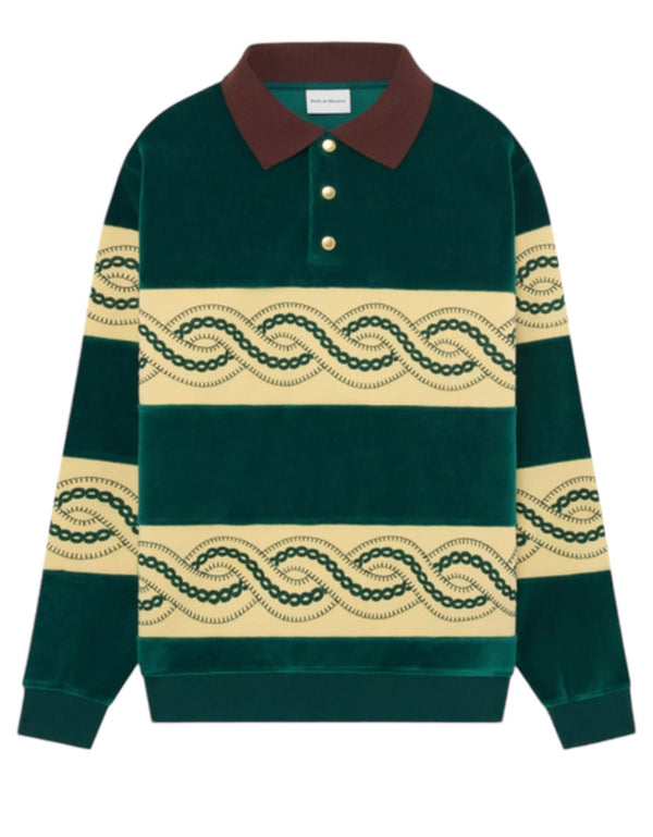 The DROLE DE MONSIEUR E-PL133-CO171-DGN Le Polo Sweat in dark green features a luxurious velvet fabric with a contrasting brown collar, three gold buttons, and distinctive cream bands adorned with a wavy green pattern across the chest and sleeves.