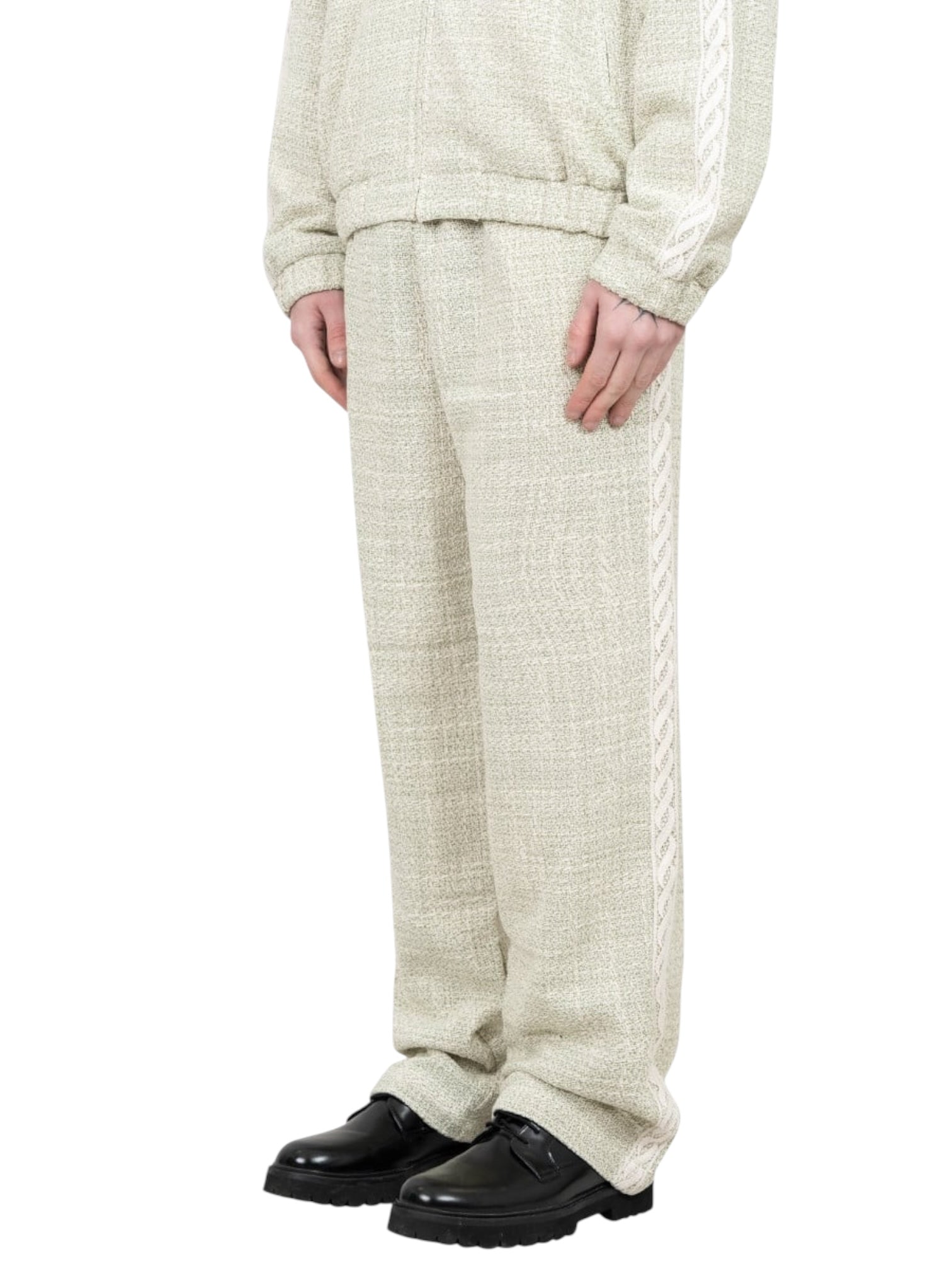 A person wearing Drôle de Monsieur G-BP183-CO186-LGN Pantalon Tweed Grn with an elasticated waist and side stripes, paired with a matching jacket and black shoes.