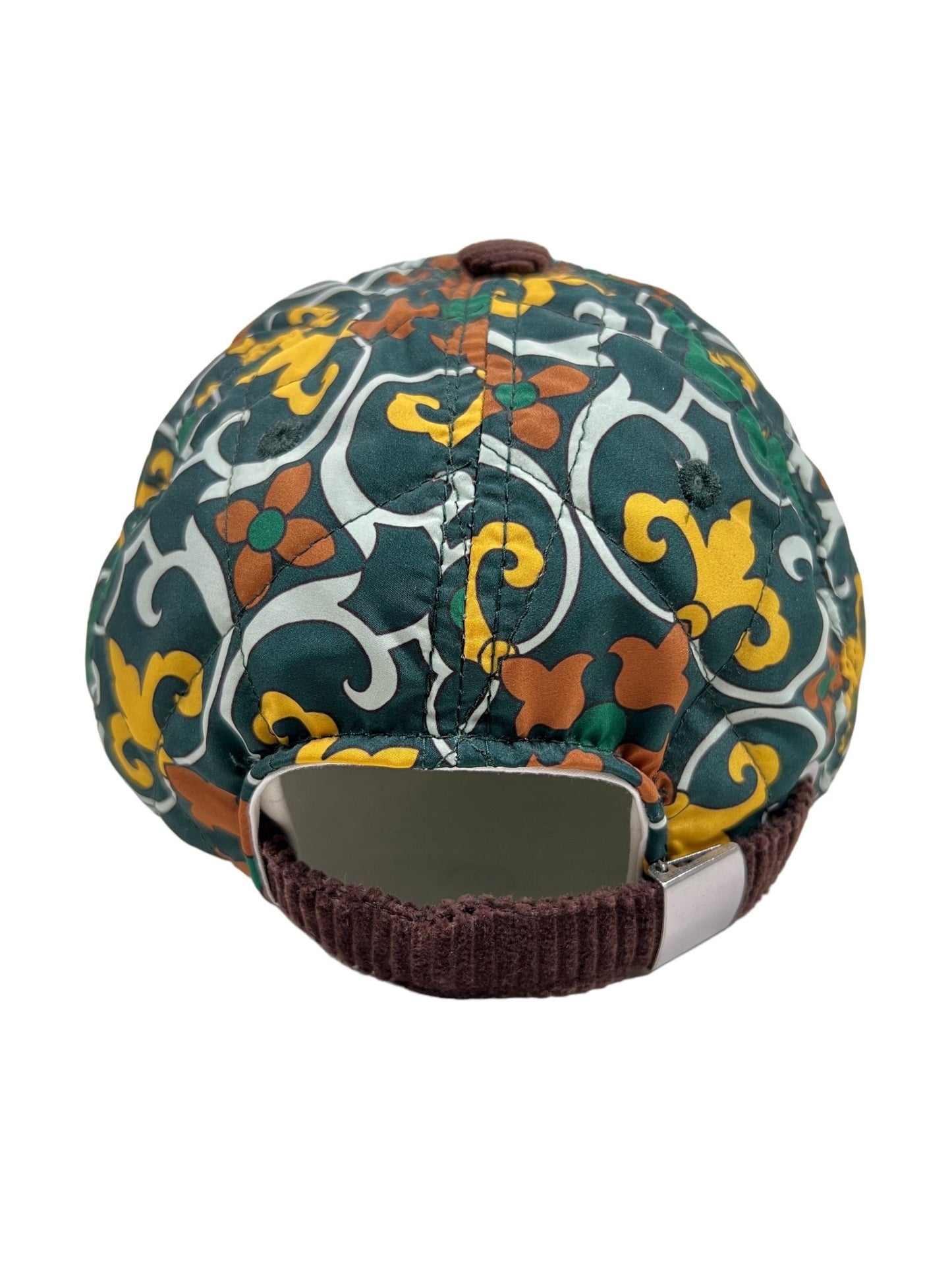 The DROLE DE MONSIEUR HAT B-CP123 LA CASQUETTE FAIENCE GREEN by DROLE DE MONSIEUR is a stylish cap featuring floral and swirl patterns in yellow, green, and brown. Crafted from durable nylon fabric, it includes a brown strap and an adjustable closure at the back.