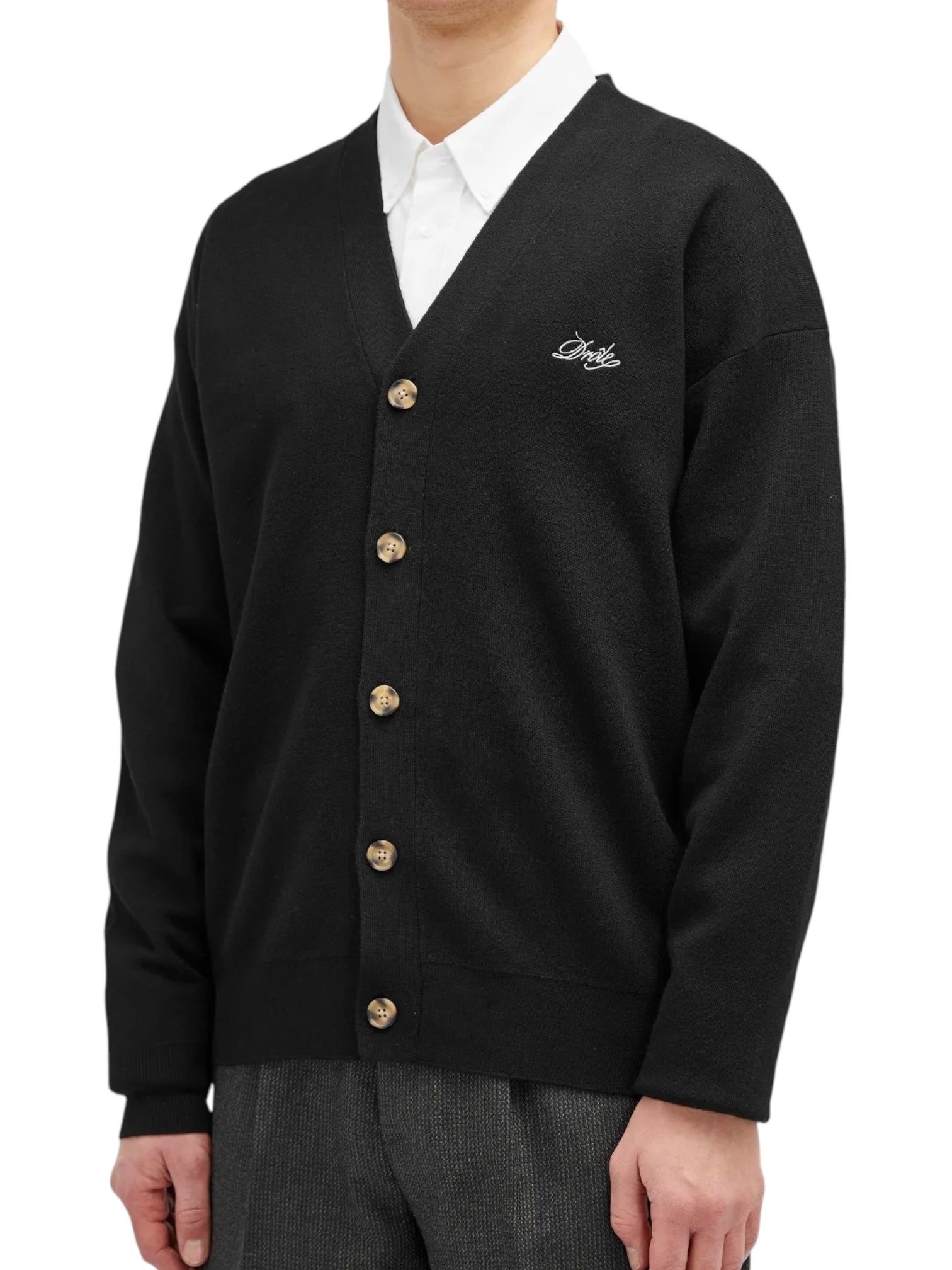 Someone is wearing a black Drôle de Monsieur cardigan (Perm-CA123-WO007-BL) with Drôle embroidery, paired with a white shirt.