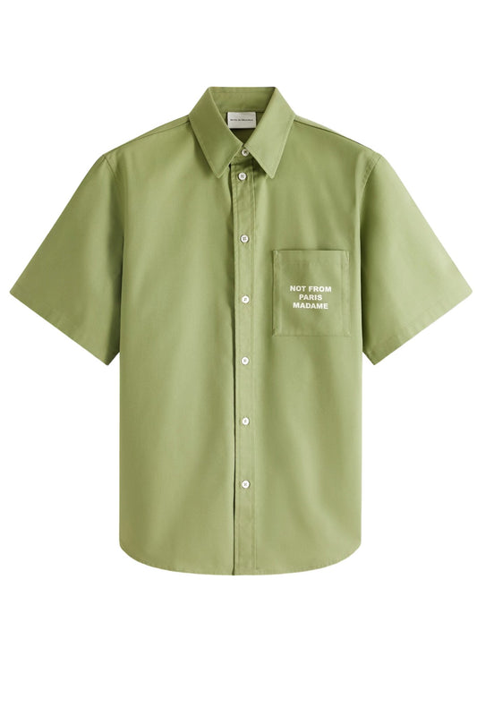 Short-sleeve Drole de Monsieur olive-green shirt with a printed slogan on the front pocket, labeled "not from madame".