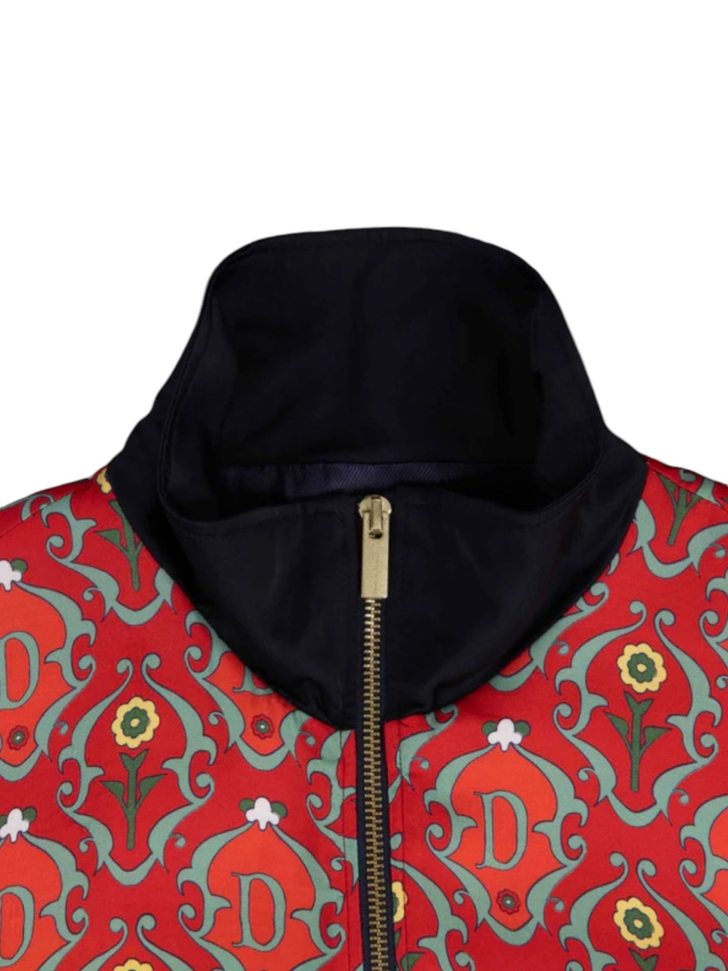 Close-up of the Drôle de Monsieur TRK Jacket D-JT167-VI008 La Veste Survet Rd, showcasing an ornate red and green pattern with yellow and white floral designs and the letter "D." It features a navy high collar, a gold zipper, and is crafted in Portugal for an exclusive touch.