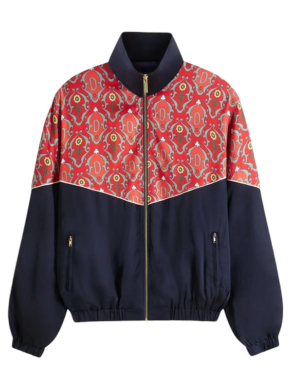 The Drôle de Monsieur TRK Jacket D-JT167-VI008 La Veste Survet Rd showcases a vibrant design with its red and green patterned upper section and solid navy lower section. Featuring a front zipper and elastic cuffs, this stylish track jacket is made in Portugal, blending comfort with eye-catching style.