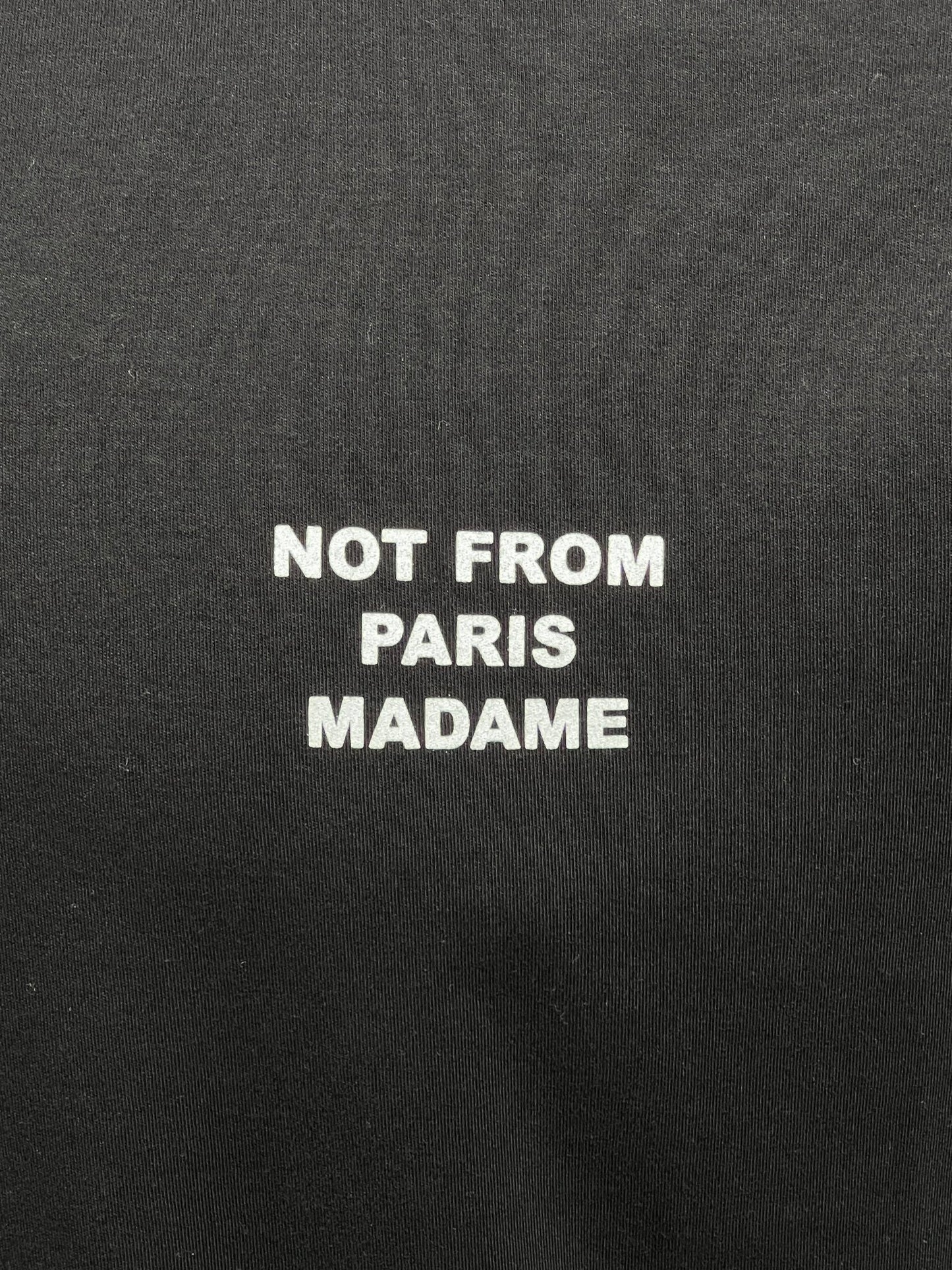 This DROLE DE MONSIEUR TS203-CO002-BL LE T-SHIRT SLOGAN BLACK 100% cotton slogan tee features black fabric with white text that proudly declares, "NOT FROM PARIS MADAME.