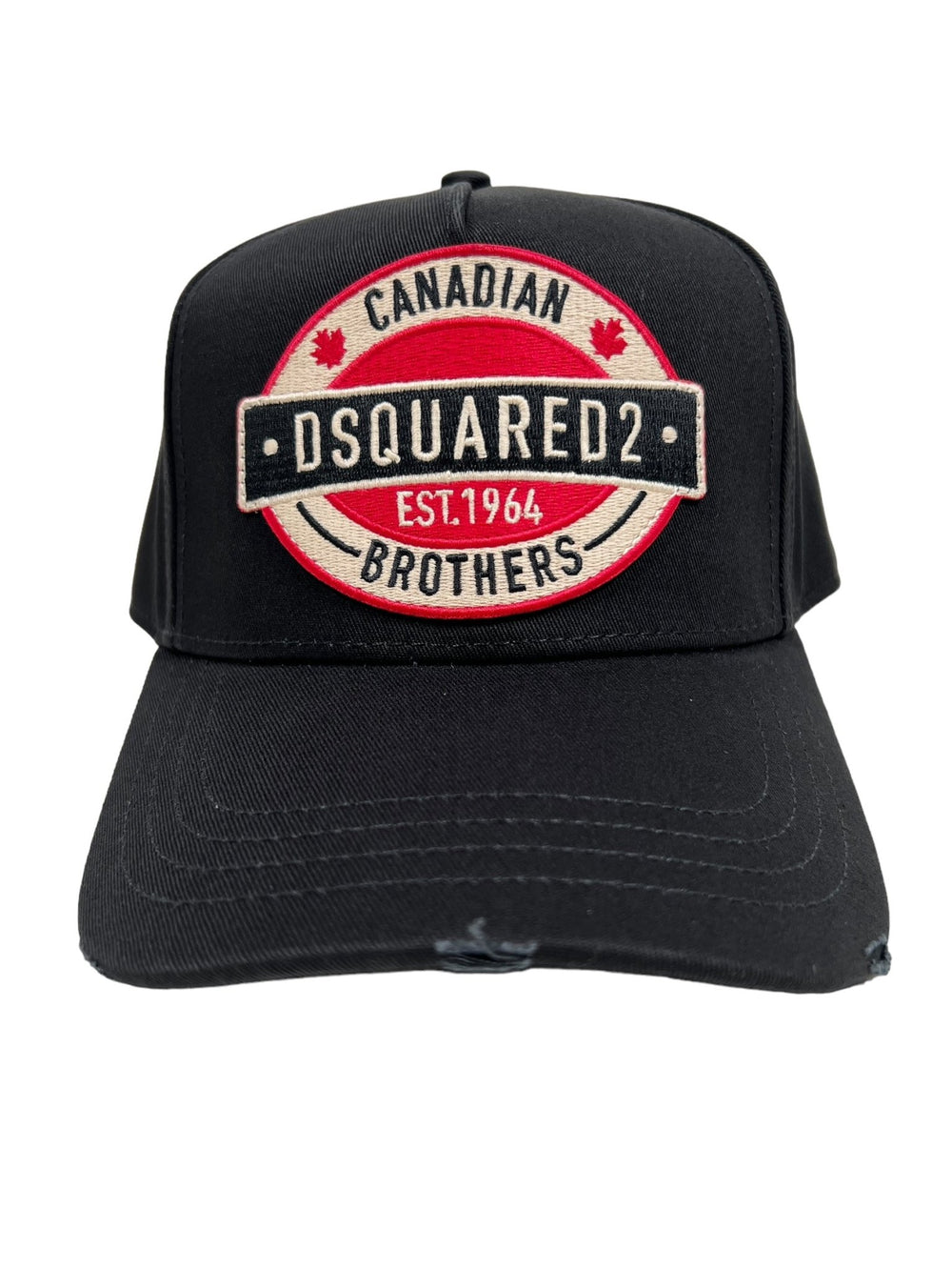 The DSQUARED2 BCM0621 Logo Baseball Cap in color 2124 is a black cotton cap featuring an embroidered patch that reads "Canadian Dsquared2 Brothers Est. 1964" in white and red letters, and it comes with an adjustable strap for a comfortable fit.