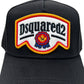 The Dsquared2 BCM0847 Logo Cap in Nero from DSQUARED2 is made of cotton gabardine, showcasing a vibrant red, white, and yellow patch with star and ribbon designs, along with distressed details for an edgy look.