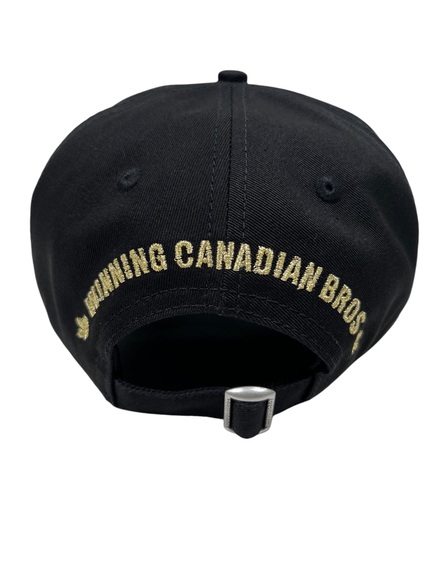 The DSQUARED2 BCM0903 Baseball Cap Gabardine-Nero showcases a back view with an adjustable strap and "RUNNING CANADIAN BROS" embroidered in gold, offering a stylish accessory option.