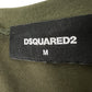 Close-up of a black label with "DSQUARED2" and "M" in white, expertly stitched onto olive fabric, showcasing the iconic style of the Dsquared2 S71Gd1462 Cool Fit Tee Green.