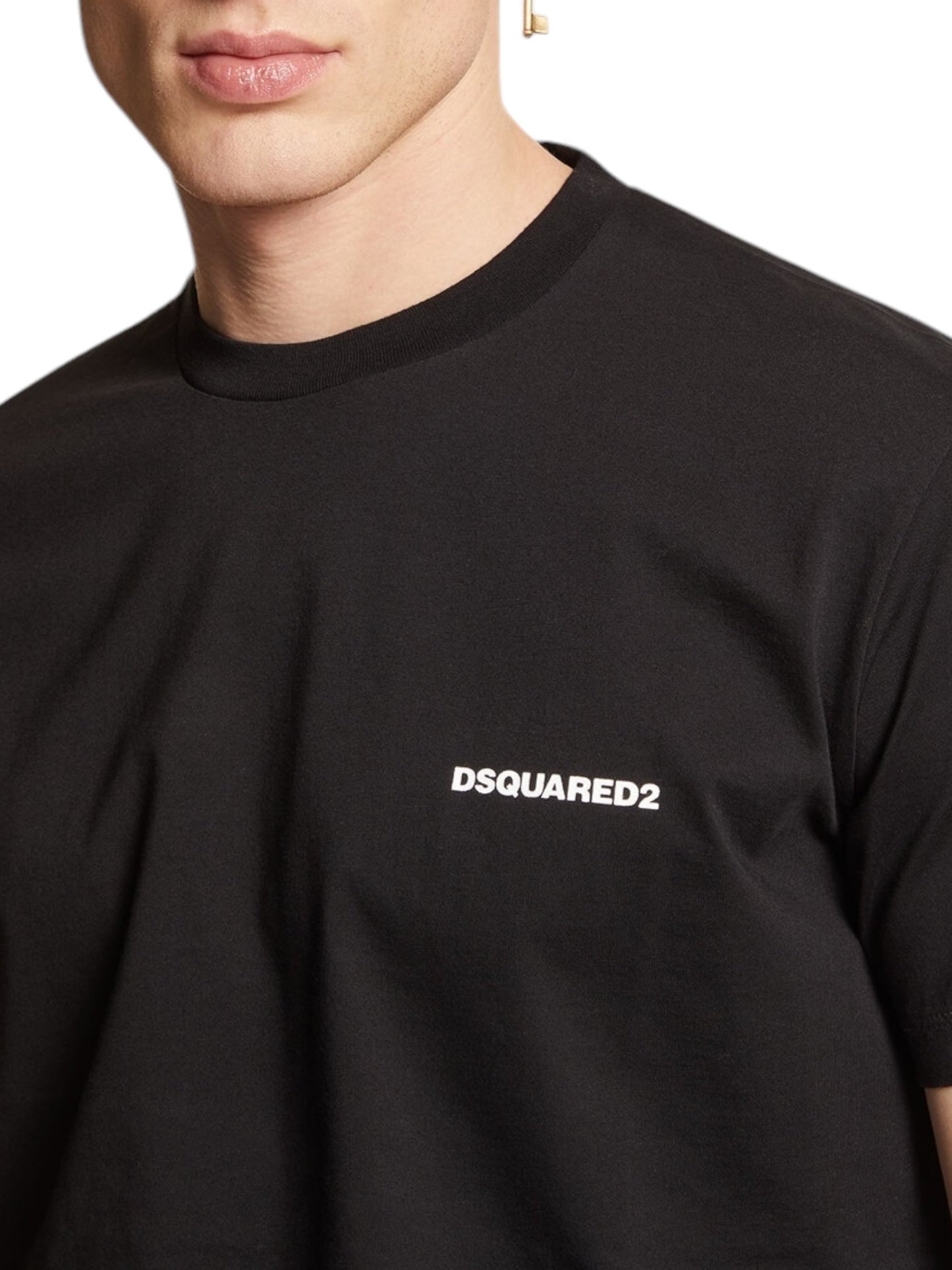 Wearing the effortlessly stylish Dsquared2 S74Gd1338 Cool Fit Tee Black, this individual highlights a quintessential piece of men's fashion with "DSQUARED2" prominently displayed across the chest.